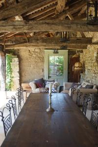 a large wooden table in a room with chairs at Mas De Garrigue - Chambres d'hôtes in Calvignac