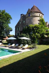 a building with a pool in front of a house at Mas De Garrigue - Chambres d'hôtes in Calvignac