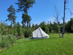 a white tent in a field with trees at Glampingtält in Österbybruk