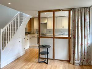 a kitchen with white cabinets and a stool in a room at Militia Cottage in Marlborough +7 photos