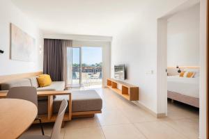 a hotel room with a bed and a couch and a table at Inturotel Cala Azul in Cala d´Or +60 photos