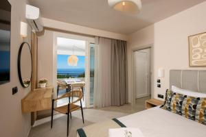 a bedroom with a bed and a desk and a dining room at Olea Mare Suites in Koinyra