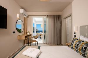 a hotel room with a bed and a desk with a view at Olea Mare Suites in Koinyra