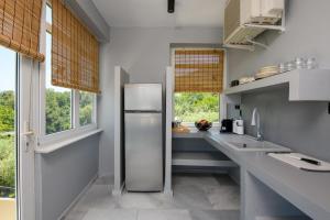 a kitchen with a stainless steel refrigerator and windows at Olea Mare Suites in Koinyra