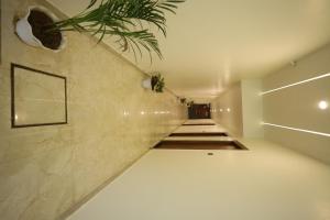 a hallway with a white tile floor and a staircase at L Roy in Meerut +4 photos