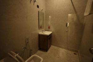 a bathroom with a sink and a shower and a toilet at L Roy in Meerut