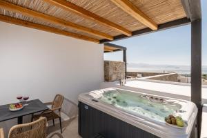 a hot tub on the balcony of a house at Lithia Exclusive Villas & Suites in Plaka