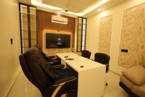 a meeting room with chairs and a table and a tv at L Roy in Meerut
