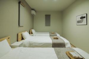 two beds in a room with white sheets at Green Peak 2 in Aso