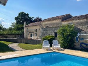 two chairs and a swimming pool in front of a house at Rural French Gite Sleeps 8 with Pool and Parking in La Croix-Comtesse