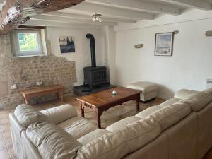 a living room with a couch and a wood stove at Rural French Gite Sleeps 8 with Pool and Parking in La Croix-Comtesse