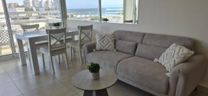a living room with a couch and a table at 16 SANDY BEACH in Larnaca