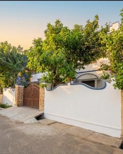 a white fence with trees in front of a house at Lazars homestay in Fort Kochi