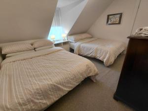 a bedroom with two beds and a window at Aberlour Cottages - Bolthole & Retreat in Aberlour