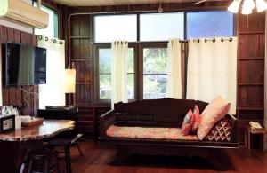 a living room with a bench in front of a window at Khom Chiang Mai in Chiang Mai