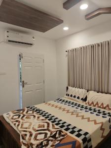 a bedroom with a bed with a blanket on it at The Beach House Marari in Mararikulam