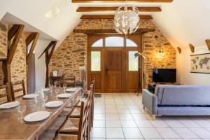 a dining room with a long table and a couch at Gite Le Ginestou in Almon-les-Junies