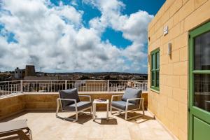 a patio with two chairs and a table on a balcony at Casa Radiant in Rabat +59 photos