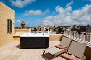 a hot tub on a balcony with two chairs at Casa Radiant in Rabat
