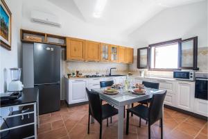 a kitchen with a table with chairs and a black refrigerator at La Suara Manna - Happy Rentals in Telti