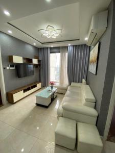 a living room with a couch and a tv at Vinhomes D'Capitale - Amee Apartment in Hanoi