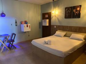 a bed in a room with a table and a chair at Rota 69 motel in Porto Nacional