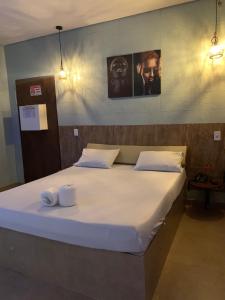 a large bed in a room with two towels on it at Rota 69 motel in Porto Nacional