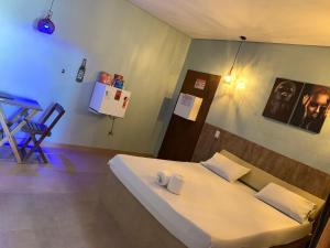 a bedroom with a bed and a chair in it at Rota 69 motel in Porto Nacional