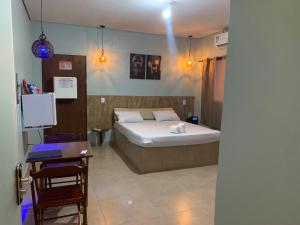 a bedroom with a bed and a table and a desk at Rota 69 motel in Porto Nacional +2 photos