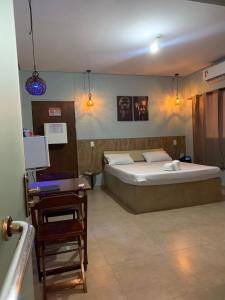 a bedroom with a bed and a chair and a desk at Rota 69 motel in Porto Nacional