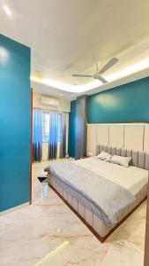 a bedroom with a large bed with a blue wall at Om Sai Ram Hotel in Rājūra