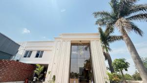 a building with a large window and a palm tree at Om Sai Ram Hotel in Rājūra