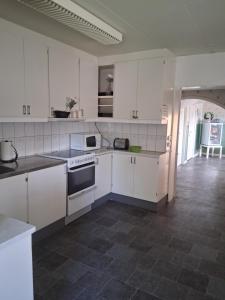 a kitchen with white cabinets and a tile floor at Skärplinge Gästis B&B in Skärplinge