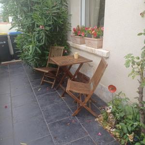 a wooden table and two chairs on a patio at Apt cosy dans maison de charme in La Rochelle