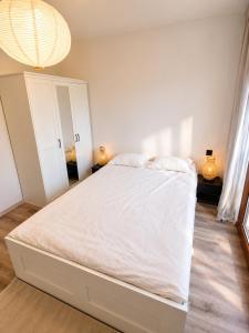 a white bed in a bedroom with a chandelier at Zielone drzwi in Żywiec