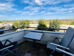 a table and chairs on a balcony with a view at Strandsicht, direkt am Strand in Warnemünde