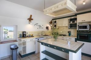 a kitchen with white cabinets and a large island at Gite Le Ginestou in Almon-les-Junies