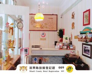 a room with a desk and a clock on the wall at Hsin Hsin Hotel in Miaoli