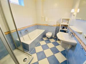 a bathroom with a tub and a toilet and a sink at Ferienhaus Jan in Warnemünde +16 photos