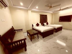 a hotel room with two beds and a couch at Sterlinge Homestay in Visakhapatnam