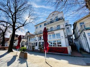 two red umbrellas in front of a hotel at Doppelzimmer Zapfhahn, direkt am Alten Strom in Warnemünde