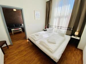 a bedroom with a bed with white sheets and a window at Doppelzimmer Zapfhahn, direkt am Alten Strom in Warnemünde