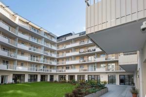 an apartment building with a lawn in front of it at DOMITYS Les Mosaïques in Rouen
