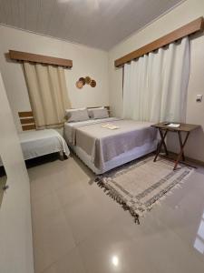 a bedroom with two beds and a table in it at Hotel Coração Verde in Alter do Chao