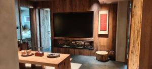 a living room with a large television and a table at 忘寂民宿 in Zhangjiajie