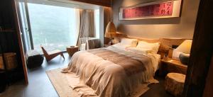 a bedroom with a bed and a large window at 忘寂民宿 in Zhangjiajie