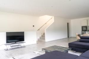 a white living room with a couch and a tv at Villa Sementina - Luxury Stay with Pool and Gym - 15 m to Lake Maggiore in Bellinzona +64 photos
