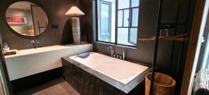 a bathroom with a large tub and a mirror at 忘寂民宿 in Zhangjiajie