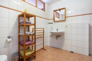 a bathroom with a sink and a shelf with towels at Alte Scheune in Putbus +96 photos