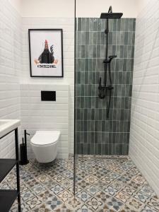 a bathroom with a toilet and a glass shower at Szumi Las Bed & Breakfast in Józefów